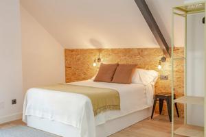 a bedroom with a white bed and a glass shower at Apartamentos As Barxas Playa in Moaña