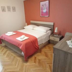 1 dormitorio con 1 cama con 2 toallas en Apartments Smiljana Mucić, en Makarska