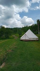 a large white tent in a field of grass at Glamping in the apuseni mountains in Grohoţele