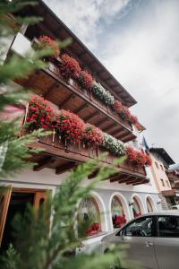 a building with flower boxes on the side of it at Hotel Eccher 3 stelle Superior in Mezzana