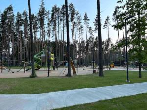 un parque con parque infantil con tobogán y árboles en House in Pine forest Asari, en Jūrmala
