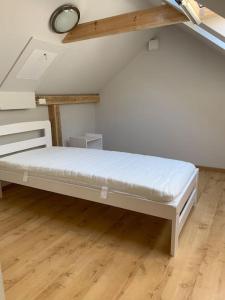 Cama blanca en habitación con suelo de madera en House in Pine forest Asari, en Jūrmala