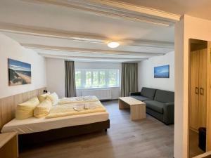 1 dormitorio con 1 cama y 1 sofá en Ferienhotel Alter Bahnhof garni en Prerow
