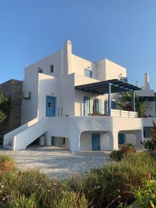 a white house with a staircase in front of it at Seaside Paros Ampelas in Ambelas
