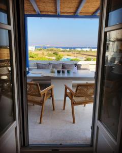 a view of a patio with two chairs and a table at Seaside Paros Ampelas in Ambelas