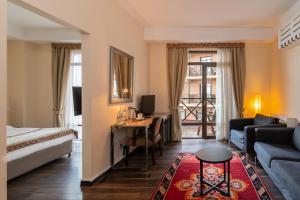 um quarto de hotel com uma cama e uma secretária com um computador em GINGER Hotel em Tbilisi