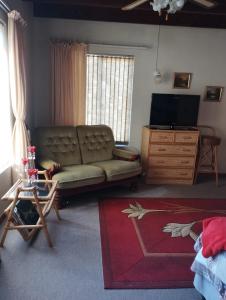 a living room with a couch and a television at Seesterkloof in Stilbaai