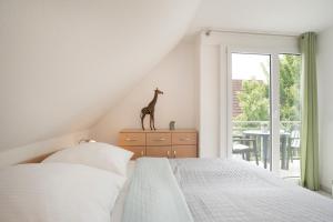 um quarto com uma cama e uma estátua de girafa numa cómoda em Haus Waidmannsruh Hubertus em Kellenhusen
