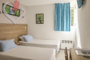 a hotel room with two beds and a window at HOTEL RESTAURANT OLYMPE in Aix-en-Provence