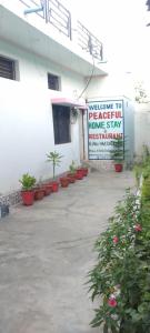 um sinal na lateral de um edifício com vasos de plantas em Peaceful Home Stay em Khajurāho
