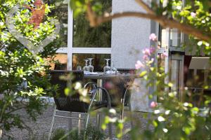 a table and chairs in a garden with flowers at HOTEL RESTAURANT OLYMPE in Aix-en-Provence