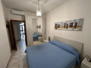 a bedroom with a blue bed and a mirror at Villa Maccioni in Budoni