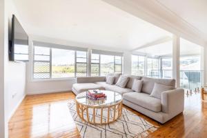 a living room with a couch and a table at Kiama Beach House & Private Beach & Newly Renovated in Kiama