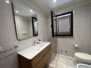 a bathroom with a sink and a toilet and a mirror at Villa Maccioni in Budoni +24 photos