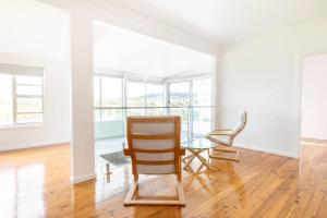 uma sala de estar com uma cadeira e uma mesa de vidro em Kiama Beach House & Private Beach & Newly Renovated em Kiama