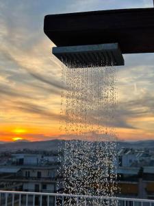 une douche avec un coucher de soleil derrière une ville dans l'établissement Eagle's Nest, à Athènes