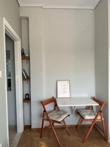 une table blanche et deux chaises dans une pièce dans l'établissement Eagle's Nest, à Athènes