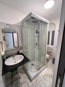 a bathroom with a glass shower and a sink at GladiatoRooms Rome - Colosseo in Rome