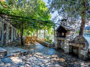 a stone house with a fireplace in a yard at Petra Mare Apartments in Alyki