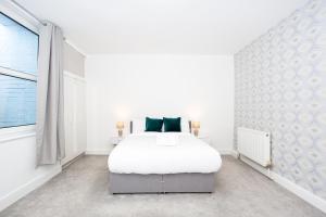a white bedroom with a white bed and a window at Beach Walk by Sorted Stay in Southend-on-Sea