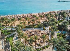 einen Luftblick auf einen Strand mit Palmen und Sonnenschirmen in der Unterkunft Iberotel Makadi Beach in Hurghada