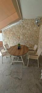 Una mesa y sillas en una habitación con una pared de piedra. en Villa Bobakis, en Nikiti