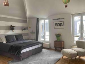 Schlafzimmer mit einem Bett, einem Stuhl und Fenstern in der Unterkunft Jolie maison de ville à 5 minutes de Paris pour 5 voyageurs parking inclus in Clichy