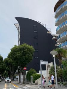 um edifício negro com pessoas a andar à frente dele em BOUTIQUE HOME LIGNANO em Lignano Sabbiadoro