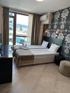 a bedroom with two beds and a large window at Briz Beach apartments - section B in Sunny Beach
