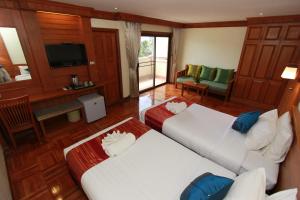 a large room with two beds and a television at Hua Hin Golf Villa in Hua Hin