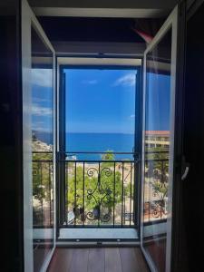 a room with a view of the ocean from a balcony at Hotel Restaurant Christophe Colomb in Calvi