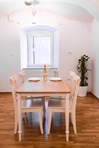 a dining room table with chairs and a bottle of wine on it at Dragon's Cave in Ljubljana