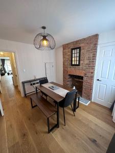 uma sala de jantar com uma mesa e uma lareira em House situated on River Itchen em Winchester