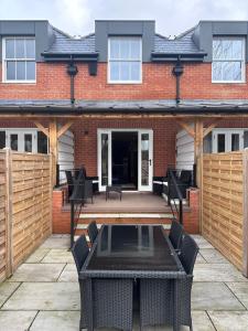 a patio with a table and chairs in front of a building at House situated on River Itchen in Winchester