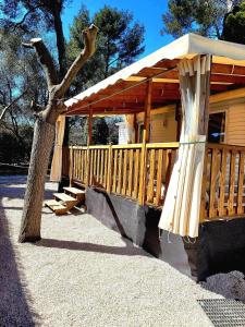 a wooden cabin with a porch and a tree at hakuna matata in La Ciotat