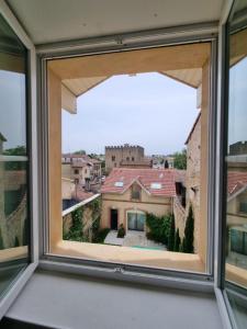 une fenêtre ouverte avec vue sur un bâtiment dans l'établissement La Maison VH, à Mont-de-Marsan