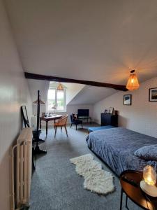 een slaapkamer met een bed en een bureau in een kamer bij La Maison VH in Mont-de-Marsan