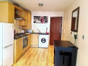 a kitchen with a white refrigerator and a washing machine at Comfortable Studio flat near Central London in London