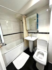 uma casa de banho com um lavatório, um WC e uma banheira em Comfortable Studio flat near Central London em Londres