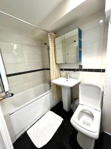 a bathroom with a sink and a toilet and a bath tub at Comfortable Studio flat near Central London in London