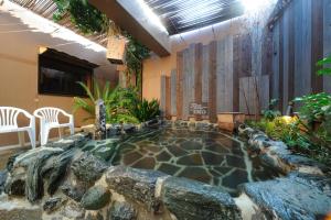 仙台Dormy Inn Sendai Station Natural Hot Springs的岩石间中间的小游泳池