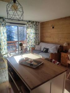 uma sala de estar com uma mesa e um sofá em Studio 4-6 couchages.pied des pistes.Résidence Montana1 em Les Deux Alpes