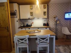 a kitchen with a counter and two stools in it at Studio 4-6 couchages.pied des pistes.Résidence Montana1 in Les Deux Alpes