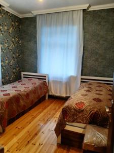 a bedroom with two beds and a window at My sweet home in Ramana in Baku