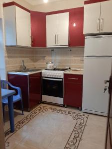 a kitchen with red cabinets and a white refrigerator at My sweet home in Ramana in Baku
