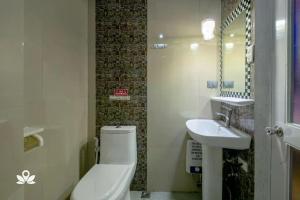 a bathroom with a toilet and a sink at Sabel Travelers Inn in Laoag