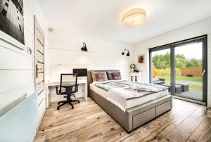 sypialnia z łóżkiem, biurkiem i oknem w obiekcie Domek hot tub jacuzzi Chillout w Kołobrzegu