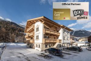 a building in the snow with cars parked in front of it at Miramonte in Sölden