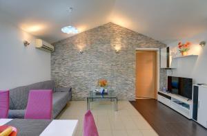a living room with a couch and a brick wall at House Jasminka in Medulin