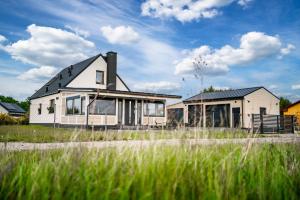 una casa sentada al lado de un campo en Domek hot tub jacuzzi Chillout en Kołobrzeg